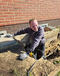 Jörg von der Sven Zöpfgen GmbH verlegt Leitungen für eine Wärmepumpe im Garten